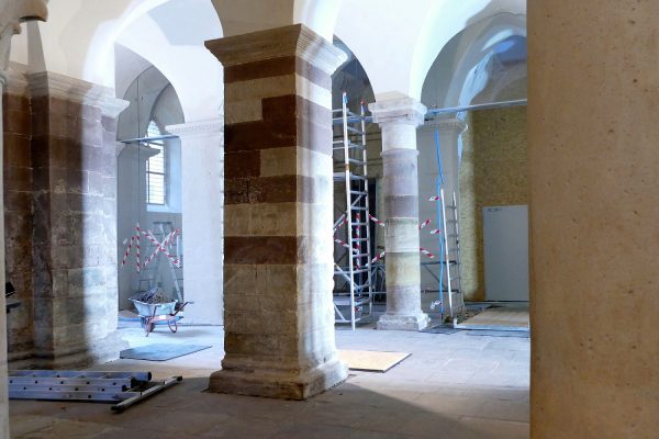 Work in Progress: Während des Einbaus der Glaselemente hat die hölzerne Staubschutzwand die Kirche von der Baustelle abgetrennt.