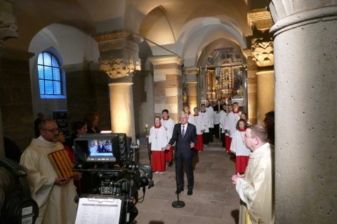 Kirchenvorstand Josef Kowalski lud in der Eingangshalle des Westwerks die Zuschauer an den Fernsehschirmen zum Mitfeiern der Heiligen Messe ein.